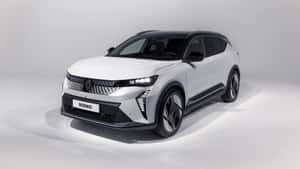 白色雷諾 Scenic SUV，帶有黑色飾邊和鋒利車頭燈，在攝影棚中。 — 雷諾 壁紙