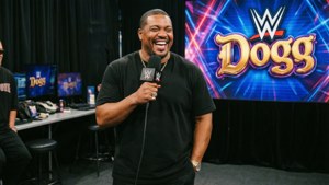 WWE主持人在Dogg螢幕前拿著麥克風大笑。