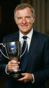 穿西裝的男士自豪地微笑著捧著AXA Legends Awards獎盃。