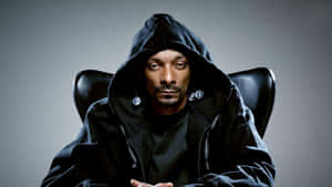 Snoop Dogg 身穿黑色連帽衫，戴著銀色耳環，坐在椅子上。 — 史努比狗狗 壁紙