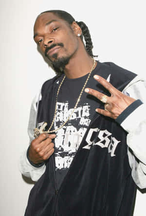 Snoop Dogg 身穿黑色天鵝絨外套和金色鏈條，做出和平手勢。 — Huawei MatePad Pro Max 壁紙
