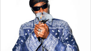 Snoop Dogg 在白色背景前身穿藍色佩斯利夾克吸食大麻煙。 — 抽菸 壁紙