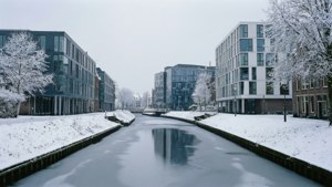 冬季雪覆蓋的城市運河，現代建築和結霜的樹木。