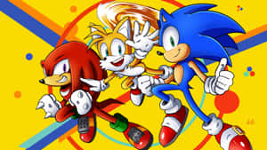 Sonic Tails 和 Knuckles 在色彩繽紛的幾何背景上豎起大拇指競速。 — 音速小子 壁紙