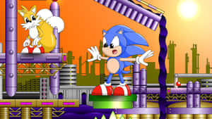 Sonic 和 Tails 在一個色彩繽紛的工業平台上，背後是日落城市景觀。 — 音速小子 壁紙