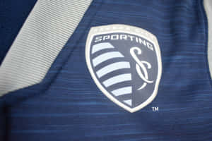 藍灰色布料上的 Sporting Kansas City 足球球衣標誌。 — 運動 壁紙