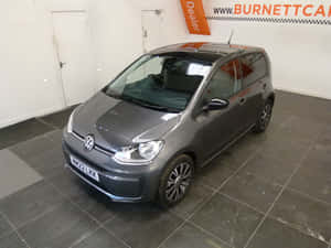 灰色Volkswagen up! 在汽車經銷商展廳中展示。 — 福斯汽車 壁紙