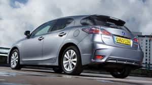 銀色Lexus CT 200h混合動力汽車停泊在潮濕的城市街道上，天空多雲。 — 凌志 壁紙