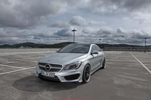 銀色Mercedes-AMG CLA45停放在空地上，上方是多雲的天空。 — Mercedes Benz C300 壁紙