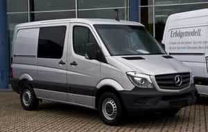 銀色 Mercedes-Benz Sprinter 客貨車停放在經銷商外。 — Steam Deck OLED 壁紙