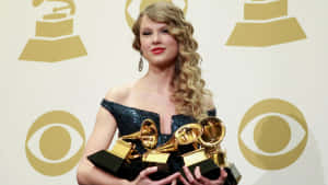 Taylor Swift 在頒獎典禮上手持葛萊美獎。 — 泰勒絲 壁紙