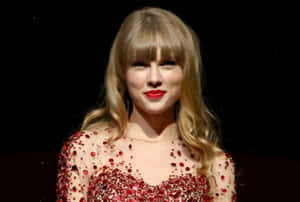 Taylor Swift 穿著紅色亮片連衣裙在舞台上微笑。 — 泰勒絲 壁紙