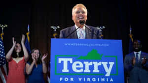 Terry McAuliffe 在維吉尼亞州的競選活動中，與歡呼的支持者和美國國旗一起。 — 政治 壁紙