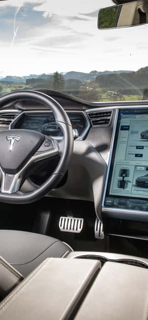 Tesla 車廂內部，配備數位儀表板和擋風玻璃外的山景。 — iPhone 11 Pro 壁紙