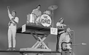 The Kinks 樂團在剪刀升降台上現場演奏，配有吉他和鼓。 — 音樂 壁紙