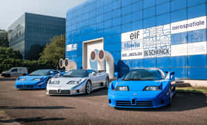三輛Bugatti EB110超級跑車停在一棟帶有贊助商標誌的藍色玻璃建築前。 — 布加迪 GIF 壁紙