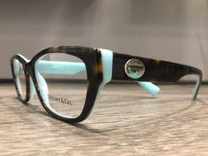 Tiffany & Co. 玳瑁眼鏡，木質表面帶有綠松石細節。 — 品牌 壁紙