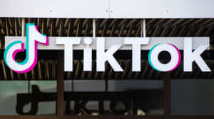 建築物上的 TikTok 標誌招牌，帶有彩色音符和白色字母。 — TikTok 動圖 壁紙