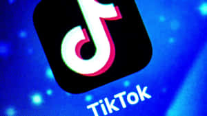 TikTok應用程式圖標在帶有像素紋理的藍色數位螢幕上發光。 — TikTok 動圖 壁紙