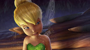 Tinker Bell 仙子在森林場景中，擁有發光的翅膀和綠色裙子。 — 小叮噹 壁紙
