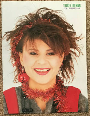 Tracey Ullman 穿著紅色閃粉節日服裝對著鏡頭微笑。 — 艾瑪·華森 壁紙