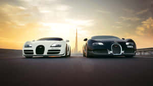 兩輛Bugatti超級跑車在沙漠公路上相對，背景是夕陽下的哈里發塔。 — 布加迪 GIF 壁紙