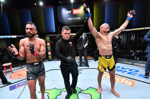 UFC 拳手在八角籠中贏得比賽，裁判舉起他的手。 — 運動 壁紙