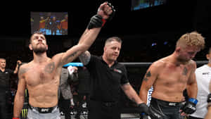 UFC拳手在八角籠內獲勝，裁判舉起他的手。 — 夜晚 壁紙