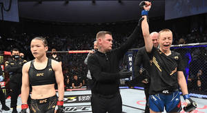 UFC拳手在比賽後舉起手臂慶祝勝利。 — 運動 壁紙