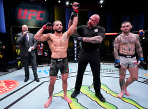 UFC拳手贏得比賽，裁判在八角籠中舉起他的手。 — 拳擊 壁紙