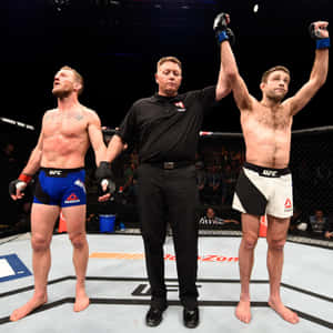 UFC拳手贏得比賽，裁判在八角籠中舉起他的手臂。 — 終極格鬥冠軍賽 壁紙