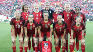 美國女子足球隊身穿紅色球衣在綠色球場上擺姿勢。 — FIFA 世界盃 壁紙