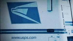 帶有藍色鷹標誌和網站文字的 USPS 送貨車 — 卡車 壁紙