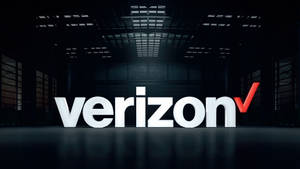 Verizon 標誌顯示在光線昏暗的工業空間，天花板很高。 — 威訊 壁紙