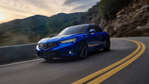 藍色Acura轎車在日落時分在蜿蜒的山路上快速行駛。 — Acura 壁紙
