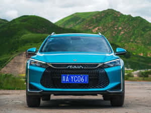 藍綠色SUV停在泥土路上，背景有綠色山丘。 — 好看汽車 壁紙