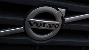 深色格柵上的 Volvo 汽車標誌，金屬飾面。 — 富豪 壁紙
