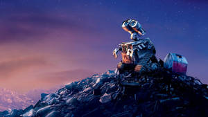 Wall-E 機器人在星空暮色天空下站在垃圾堆上，背景有山脈。