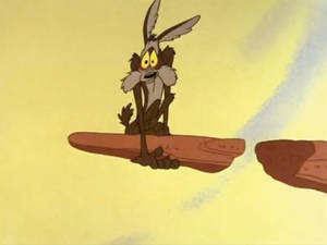 Wile E. Coyote 在沙漠場景中站在浮石上，看起來很震驚。
