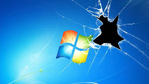在藍色背景上透過破碎玻璃可見的 Windows 標誌