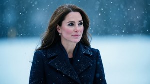 冬天站在雪中的深色外套女性