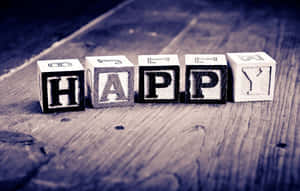 在質樸的木質表面上拼出 happy 的木塊。 — 瑜珈 壁紙