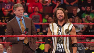 WWE 旁述員和摔角手在擂台上，紅色繩索後面有歡呼的人群。 — 摔角 壁紙