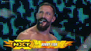 WWE摔角手Bobby Fish在舞台上咬著雪茄咧嘴笑。 — 運動 壁紙