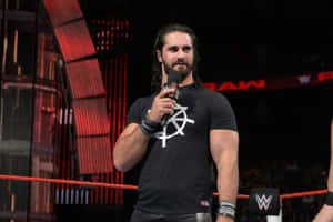 WWE摔角手Seth Rollins在摔角擂台上對著麥克風說話。 — WWE GIF 壁紙
