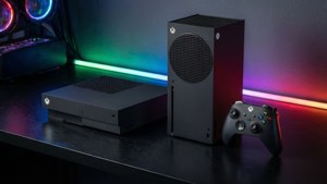 兩台 Xbox 主機和控制器放在一張有彩色 LED 燈的桌子上。 — Xbox 壁紙