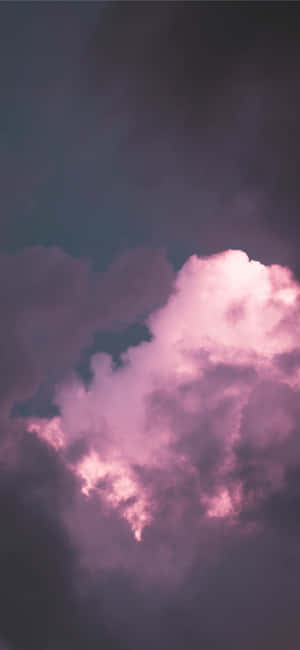 粉紅雲朵在紫色暮色天空中發光 — iPhone 15 Pro 壁紙
