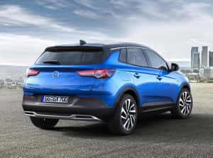 藍色Opel Grandland X SUV在多雲天氣下停泊在城市天際線附近。 — 歐寶 壁紙