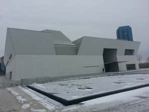 灰色冬日，現代幾何線條的博物館建築被雪覆蓋。 — 冬季美學 壁紙
