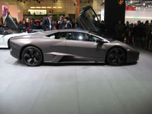 車展上啞光灰色藍寶堅尼 Reventon 打開鷗翼車門。 — 蘭博基尼 壁紙